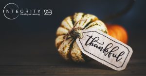 Thankful tag on white and green pumpkin with orange pumpkin in the background and Integrity Employee Leasing 20 year anniversary photo
